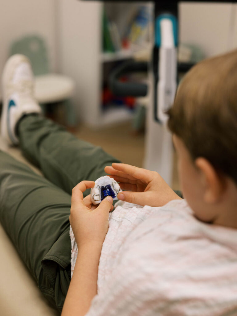 child holding dental model and appliance