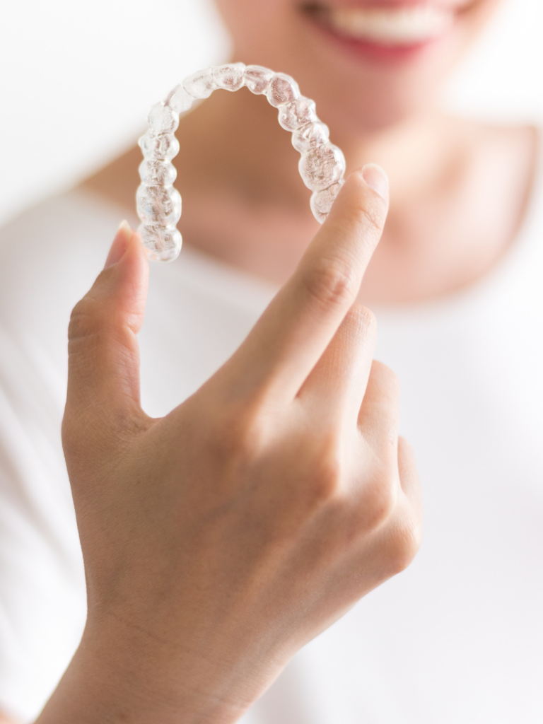 woman holding clear aligner